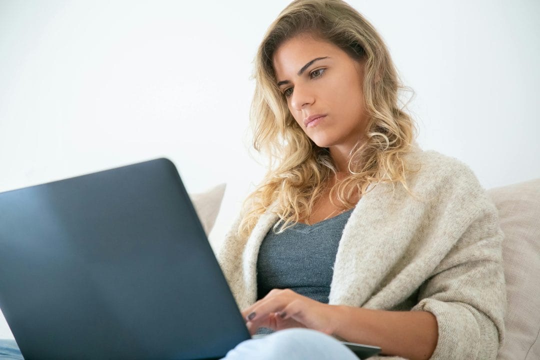 Travel blogger researching affiliate marketing opportunities on a laptop from home