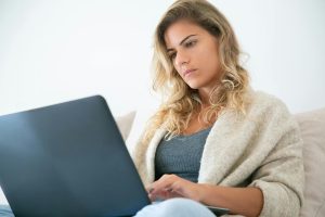 Travel blogger researching affiliate marketing opportunities on a laptop from home